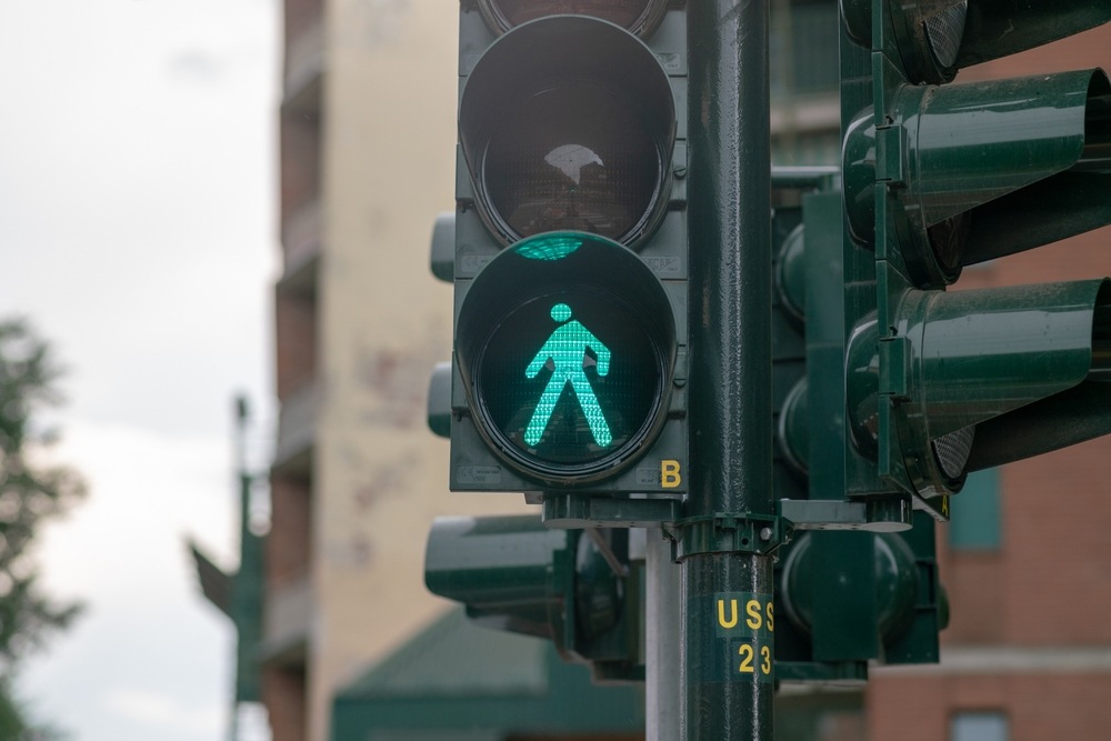 Green pedestrian crossing signal at a Wisconsin intersection representing a pedestrian's right of way and driver responsibility to yield under Wisconsin law
