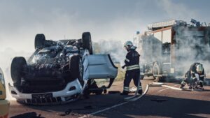 Firefighters responding to an overturned vehicle after a severe car accident that caused a catastrophic injury