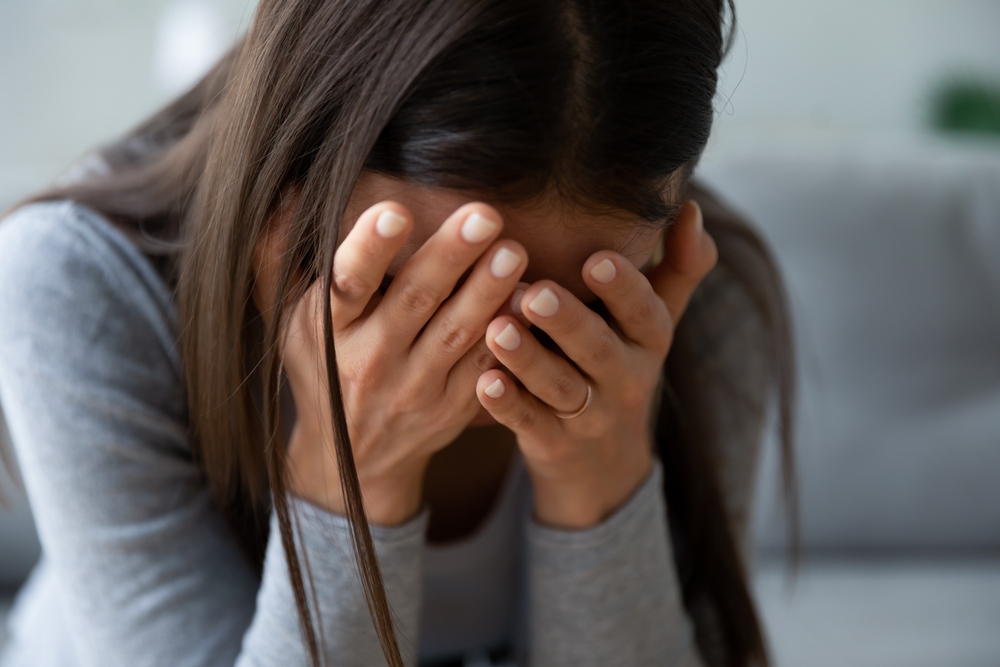 Woman covering her face in grief after losing a family member in Wisconsin