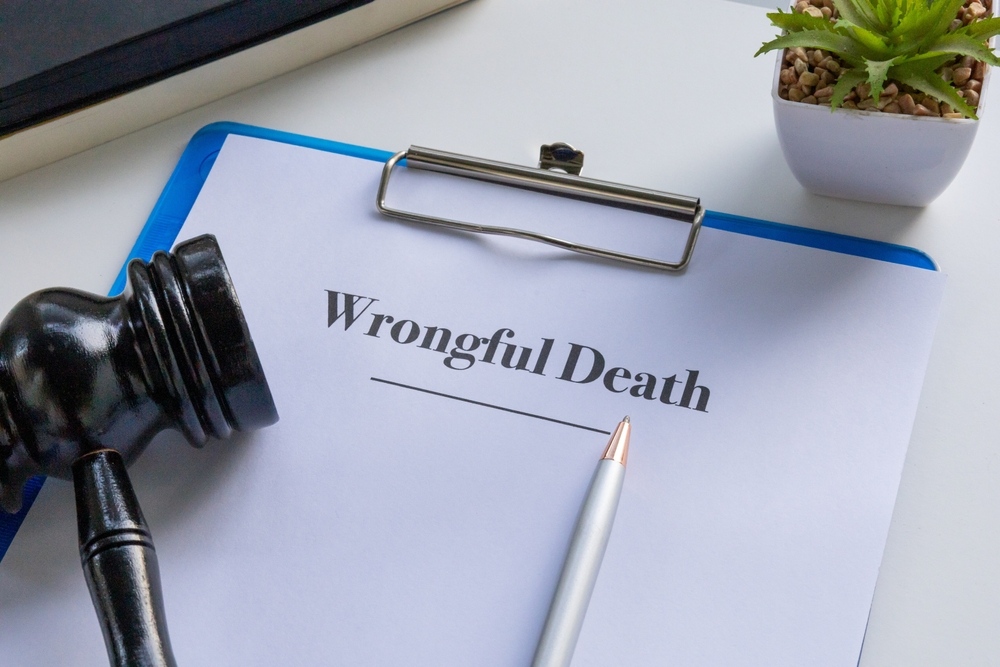 Document titled "Wrongful Death" on a clipboard next to a gavel